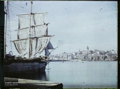 Turquie, Constantinople, Vue du Soir vers Galata. Un bateau au port. Au fond, la colline de Galata dominée par sa tour